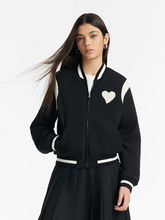 a lady in black varsity jacket with black maxi pleated skirt